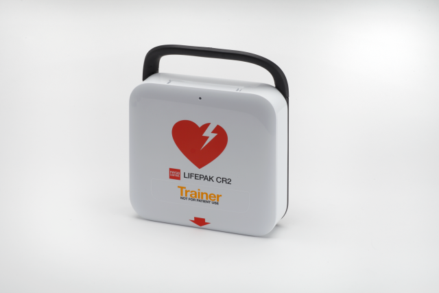 White Lifepak CR2 training defibrillator with Black carry handle and red defibrillator universal heart logo, turned to the left